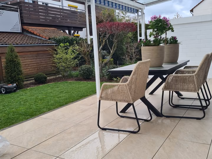 Überdachte Terrasse mit Glasdach, Essplatz und angrenzender Rasenfläche