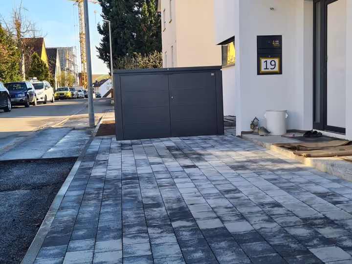 Neu gepflasterte Einfahrt eines Neubaus in der Abenddämmerung
